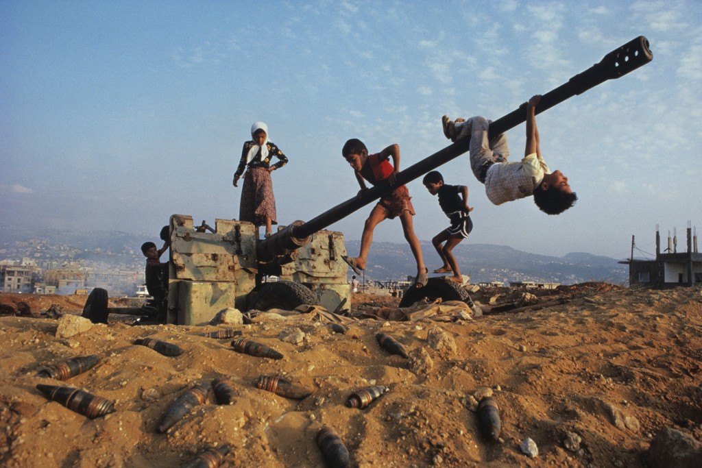 Muslim children clamber over an abandoned anti-aircraft gun near Beirut, Lebanon, 1982